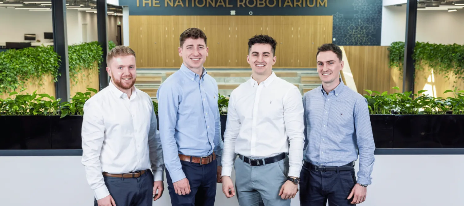 Four men standing in front of the National Robotarium sign