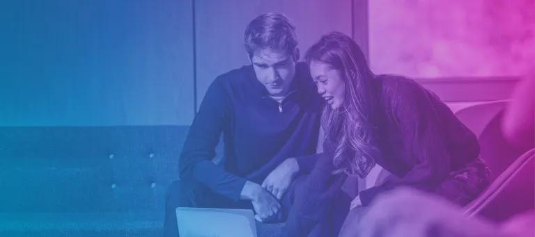 A man and women look at a laptop