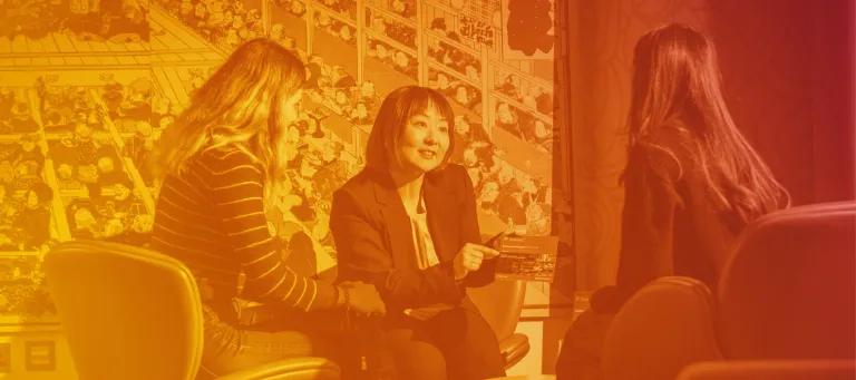 Three women sit together while talking