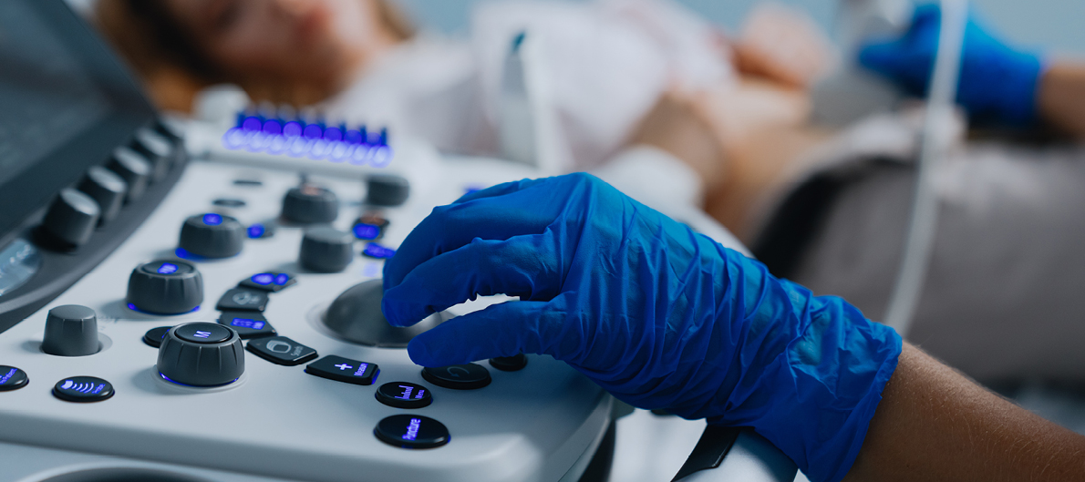 Image of gloved hand working at a piece of lab equipment with switches and dials