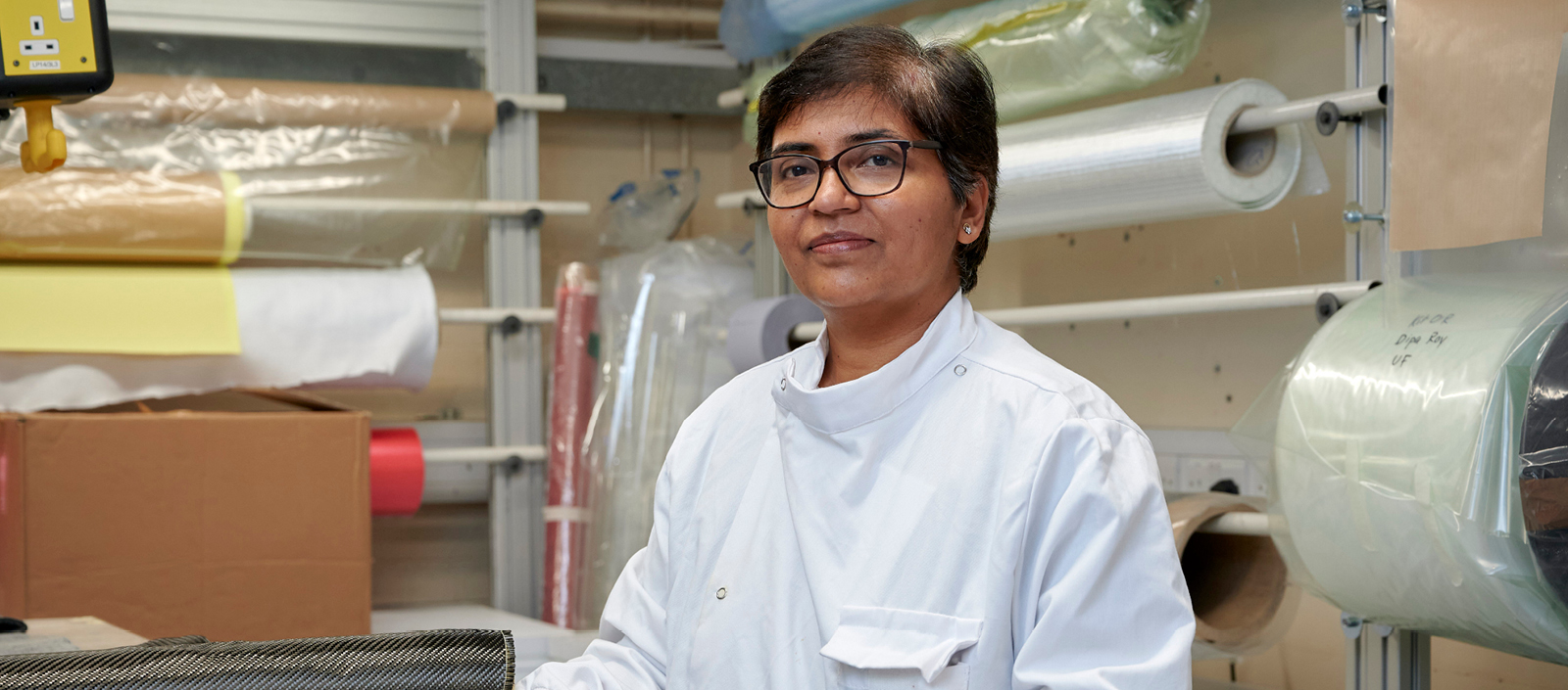 Image of Dr Dipa Roy wearing a white lab coat in her work space